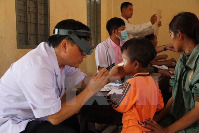Các bác sỹ trong Hội Thầy thuốc trẻ tỉnh Bình Dương khám bệnh cho trẻ em có hoàn cảnh khó khăn. (Ảnh: Huyền Trang/TTXVN)