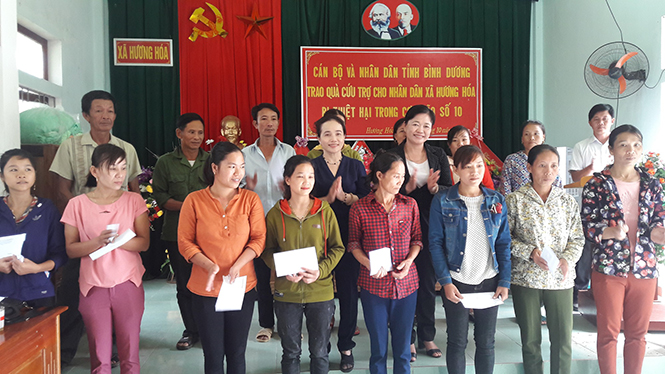 Đồng chí Trần Thị Kim Lan, Phó Chủ tịch Ủy ban MTTQVN tỉnh Bình Dương tặng quà cho các hộ dân bị ảnh hưởng của cơn bão số 10 ở xã Hương Hóa (Tuyên Hóa).