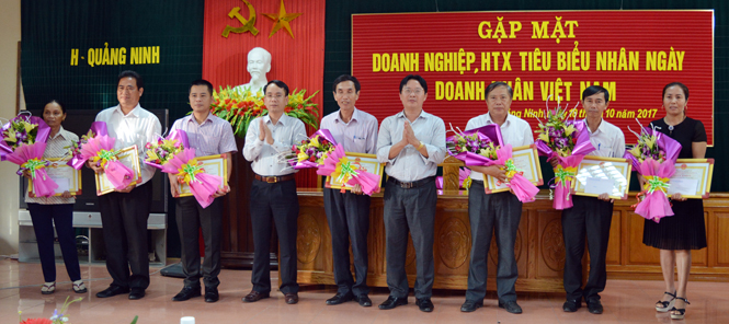 Đại diện lãnh đạo huyện Quảng Ninh trao giấy khen, hoa và quà tặng các doanh nghiệp, HTX tiêu biểu.