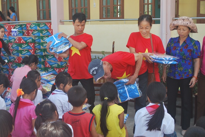 Chị Lê Thị Ngân (đứng giữa) trong một lần tổ chức chương trình “Tiếp sức đến trường”  cho các em học sinh Vân Kiều tại xã Kim Thủy, Lệ Thủy.