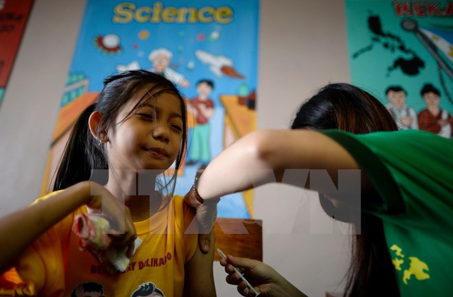 Tiêm vắcxin phòng bệnh sốt xuất huyết cho học sinh trường tiểu học Parang ở Marikina, phía tây Manila ngày 4-4. (Nguồn: AFP/TTXVN)