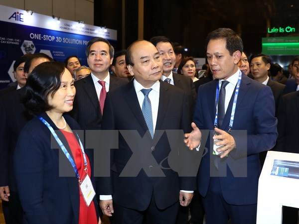 Thủ tướng Nguyễn Xuân Phúc thăm các gian hàng trưng bày tại triển lãm quốc tế về phát triển công nghiệp thông minh 2017. (Ảnh: Thống Nhất/TTXVN)