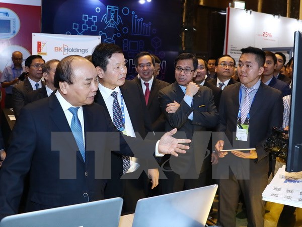 Thủ tướng Nguyễn Xuân Phúc thăm các gian hàng trưng bày tại triển lãm quốc tế về phát triển công nghiệp thông minh 2017. (Ảnh: Thống Nhất/TTXVN)