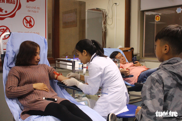  Chị Nguyễn Thị Song Thúy (ở Hà Nội) cùng con trai đến địa điểm đăng ký hiến máu tình nguyện. Đây là cách để giúp con trẻ nhận biết được tầm quan trọng của máu và dạy con có tấm lòng thiện nguyện - ẢNH: HÀ THANH