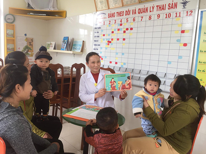 Cán bộ Trạm y tế xã Cảnh Dương hướng dẫn cách chăm sóc trẻ.