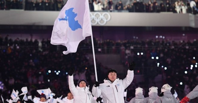 Vận động viên hai miền trên bán đảo Triều Tiên bước dưới lá cờ thống nhất trong lễ khai mạc Olympics tại Pyeongchang. (Nguồn: Getty)