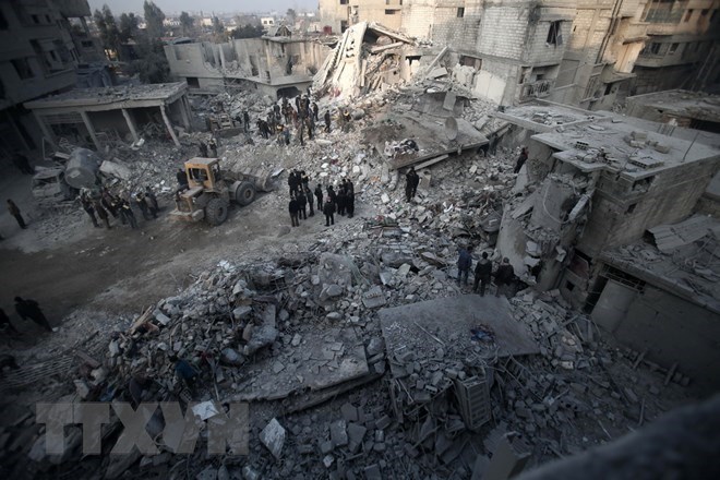 Tìm kiếm các nạn nhân sau một vụ không kích xuống Hamouria, Đông Ghouta ngày 9-1. (Nguồn: AFP/TTXVN)