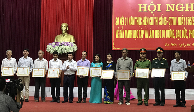 Đại diện lãnh đạo thị xã Ba Đồn tặng giấy khen thầy Nguyễn Minh Đức (thứ 6 từ trái sang) và các cá nhân điển hình tiến tiến trong thực hiện Chỉ thị số 05