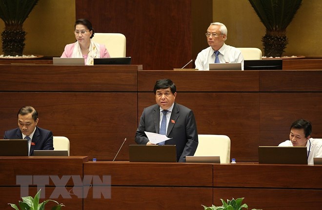 Bộ trưởng Bộ Kế hoạch và Đầu tư Nguyễn Chí Dũng báo cáo làm rõ vấn đề đại biểu Quốc hội nêu. (Ảnh: Dương Giang/TTXVN)