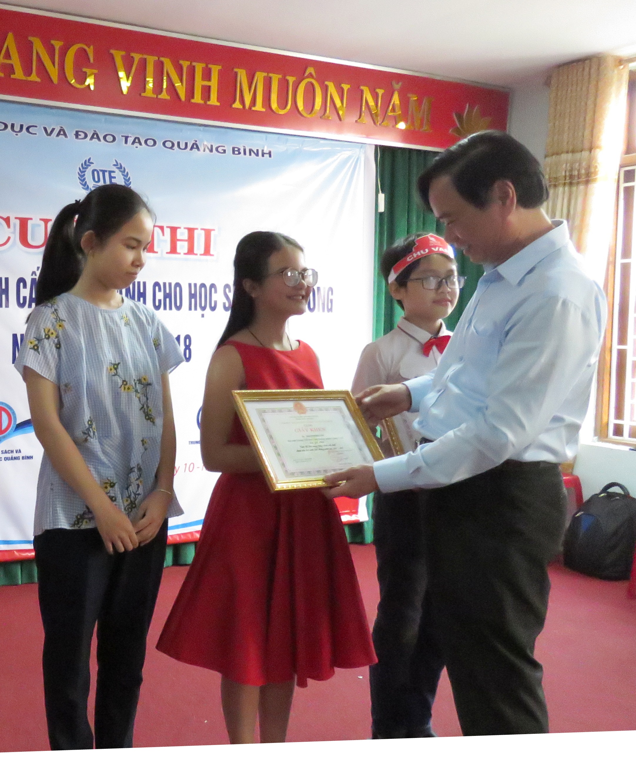 Mai Phương Linh (áo đỏ) nhận giải nhất Hội thi Tài năng tiếng Anh do đồng chí Đinh Quý Nhân, Tỉnh uỷ viên, Giám đốc Sở Giáo dục – Đào tạo trao 