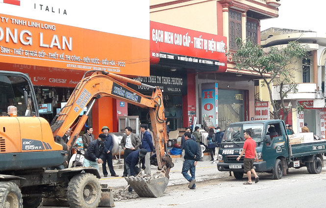 Lực lượng liên ngành giải tỏa tình trạng lấn chiếm lòng lề đường tại đường Quang Trung.