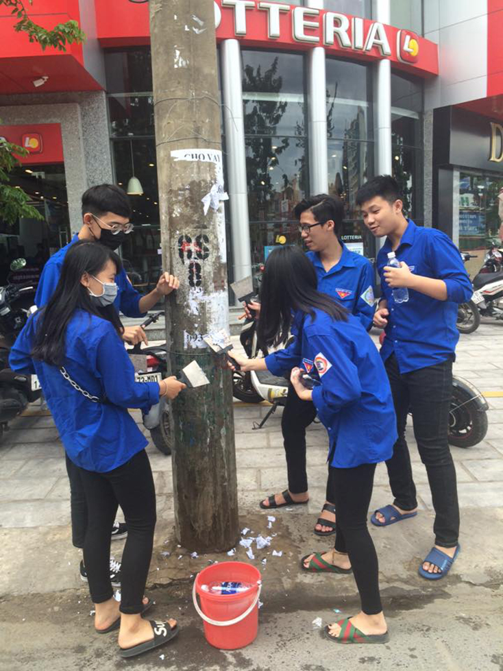 Đoàn viên thanh niên thành phố Đồng Hới bóc xóa quảng cáo rao vặt sai quy định. 