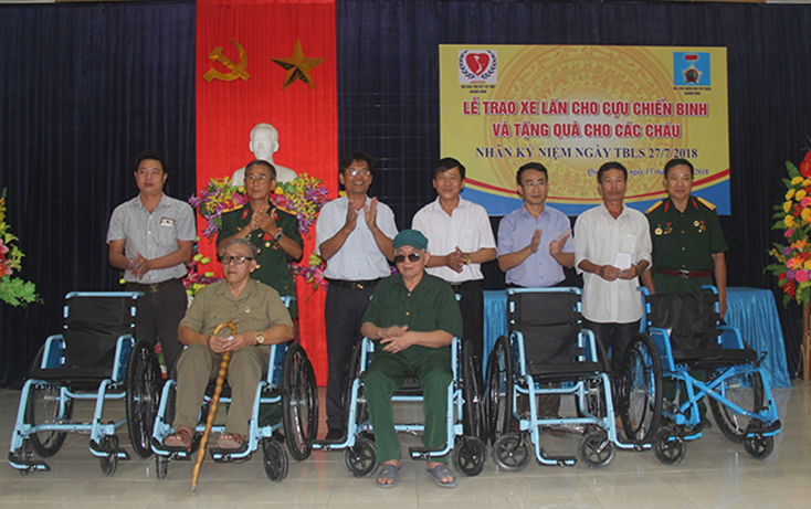 Đại diện Ban Liên lạc truyền thống CCB Quân khu Trị Thiên tỉnh Quảng Bình và Hội Bảo trợ người tàn tật và trẻ mồ côi tỉnh trao xe lăn cho các CCB.