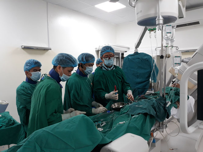 Chuyên gia y tế Nhật Bản Masakazu Nagaoka và các thành viên trong đoàn cùng các bác sĩ Bệnh viện hữu nghị Việt Nam - Cu Ba Đồng Hới thực hiện can thiệ tim mạch cho bệnh nhân tại bệnh viện