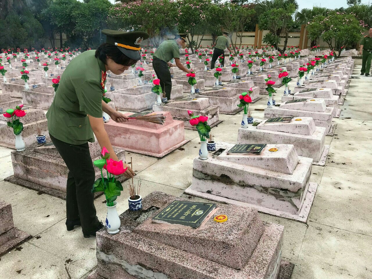 Đoàn viên thanh niên Công an tỉnh làm vệ sinh thay mới hoa tại Nghĩa trang liệt sỹ Ba Dốc.