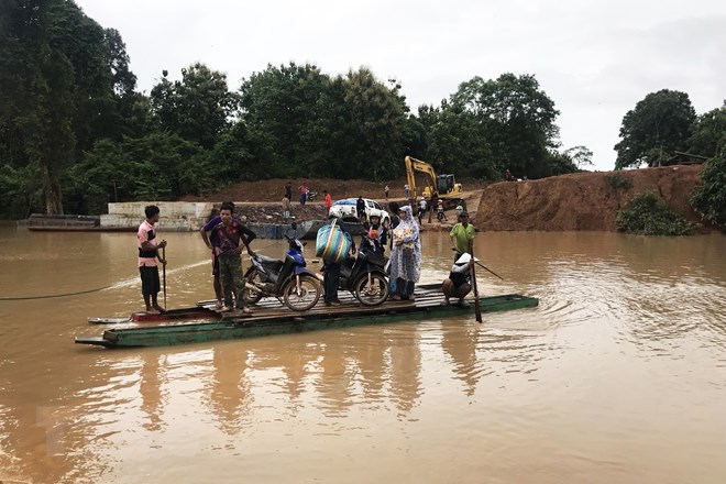 Người dân sơ tán khỏi khu vực ngập lụt do sự cố vỡ đập thủy điện Sepien Senamnoi ở huyện Sanamxay. (Nguồn: AFP/TTXVN)