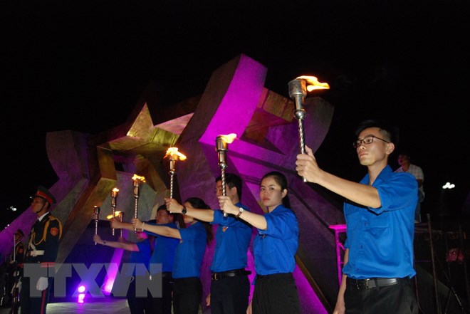 Các đoàn viên, thanh niên thực hiện nghi lễ rước đuốc ở Nghĩa trang Liệt sỹ Quốc gia Đường 9. (Ảnh: Thanh Thủy/TTXVN)