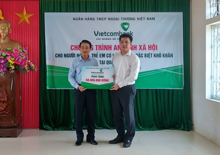 Đại diện lãnh đạo Ngân hàng Thương mại cổ phần Ngoại thương Việt Nam (Vietcombank)-Chi nhánh Sở giao dịch trao số tiền 50 triệu đồng cho Trung tâm Bảo trợ xã hội tỉnh