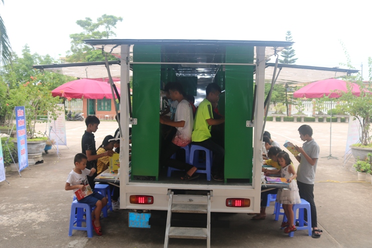 Các em học sinh thích thú với hình thức phục vụ của xe thư viện lưu động.