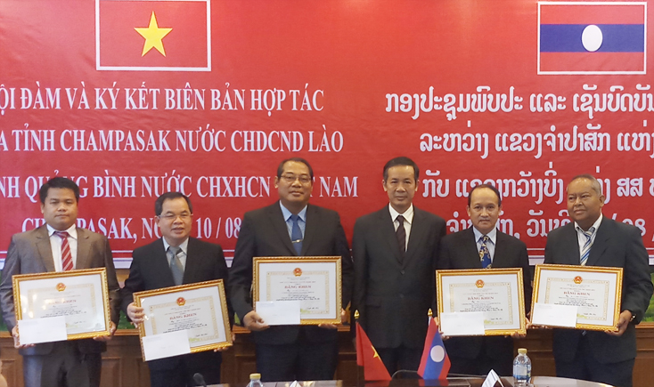 Đồng chí Phó Bí thư Thường trực Tỉnh ủy Trần Công Thuật trao Bằng khen của UBND tỉnh Quảng Bình cho các tập thể và cá nhân tỉnh Chăm Pa Sắc.