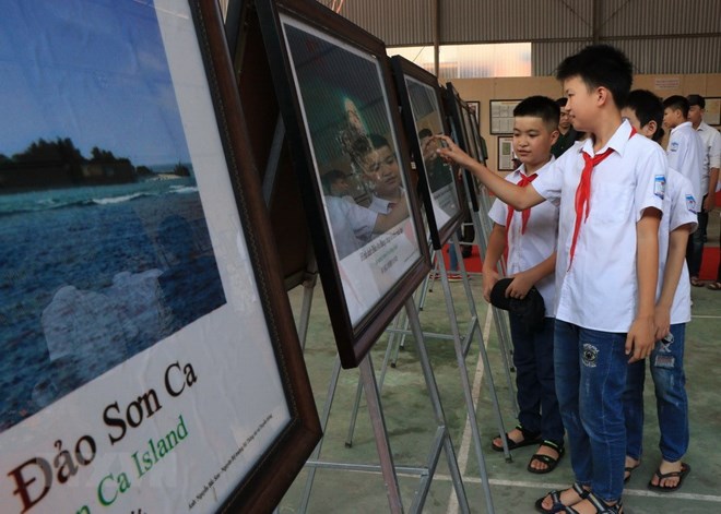 Các em học sinh tham quan triển lãm về Hoàng Sa, Trường Sa của Việt Nam. (Ảnh: Vũ Hoàng Giang/TTXVN)