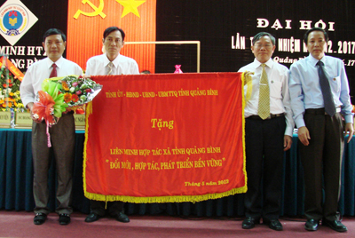 Đồng chí Hoàng Đăng Quang, Phó Bí thư Thường trực Tỉnh ủy trao tặng bức trướng của Tỉnh ủy, HĐND, UBND, UBMTTQVN tỉnh cho lãnh đạo Liên minh HTX Quảng Bình.