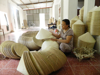 Chị Trần Thị Thêm đang kiểm tra chất lượng sản phẩm nón lá trước khi đóng gói đưa đi tiêu thụ.