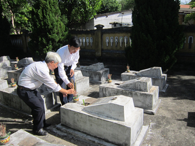 Ông Thạnh (bên phải) đang thắp hương cho các liệt sĩ tại nghĩa trang phường Nam Lý (thành phố Đồng Hới).