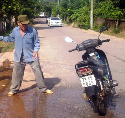 Người dân dùng nước dập tắt lửa trên chiếc xe mô tô.