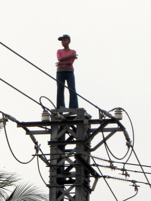 Người phụ nữ đứng trên cột điện.