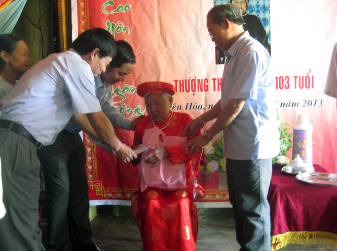 Ông Đinh Minh Thử và đại diện Qũy Nhân ái NCT Việt Nam thăm cụ bà Phan Thị Báu, 103 tuổi trú tại thôn Tân Sơn, xã Yên Hóa, huyện Minh Hóa.