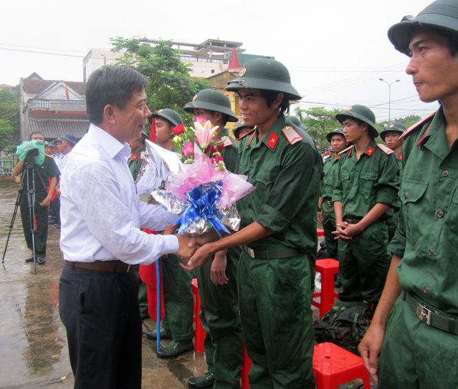 Đồng chí Nguyễn Hữu Hoài, Phó Bí thư Tỉnh ủy, Chủ tịch UBND tỉnh, Chủ tịch Hội đồng nghĩa vụ quân sự tỉnh tặng hoa và động viên tân binh huyện Quảng Trạch trước khi lên đường.