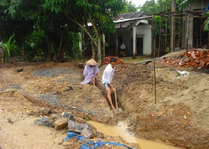 Người dân xã Đức Hóa chủ động khơi thông cống rãnh chống ngập úng.