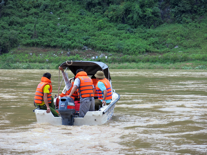 Lực lượng chức năng dùng ca nô để tìm kiếm nạn nhân.