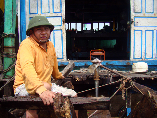 Ông Đồng Thanh Hòa ngồi bần thần bên chiếc tàu bị vỡ.