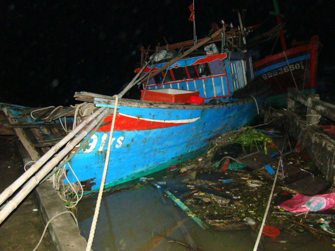 Một tàu cá bị đập vào bờ gãy đôi.