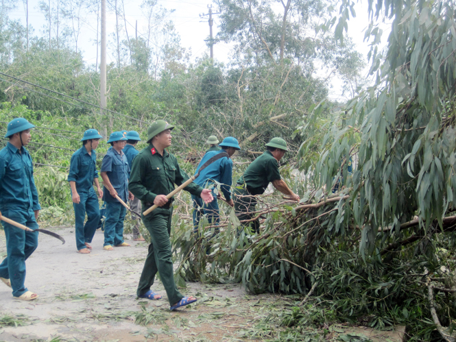 Cán bộ, chiến sỹ Ban chỉ huy Quân sự huyện Quảng Ninh cùng với lực lượng dân quân giải tỏa đường giao thông ở xã Trường Xuân.