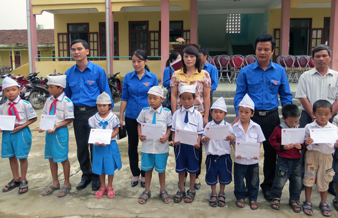 Đồng chí Dương Văn An, Bí thư trung ương Đoàn trao quà cho các em học sinh bị ảnh hưởng trong cơn bão số 10 tại trường tiểu học số 1 Đại Trạch.