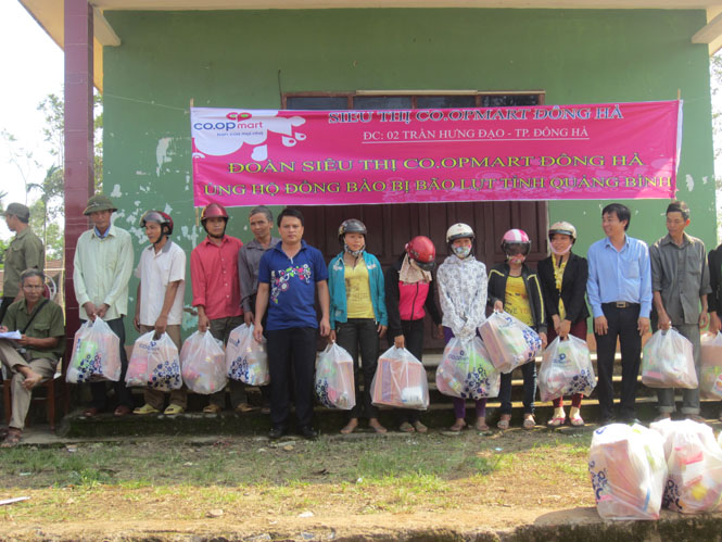 Đại diện lãnh đạo Siêu thị C.oopmart Đông Hà trao quà cho các hộ dân xã Minh Hoá