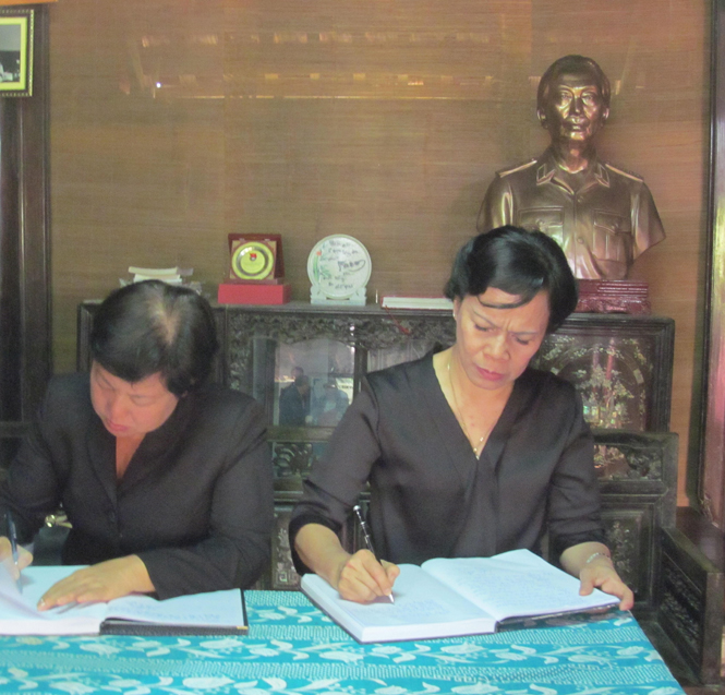 Phu nhân Chủ tịch nước Trương Tấn Sang (bên phải) đang ghi vào sổ tang.