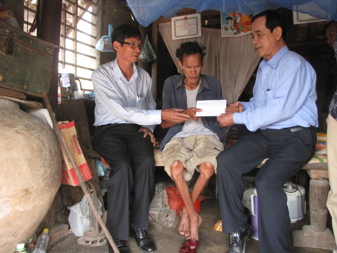 Đại diện đoàn cứu trợ tỉnh Bình Dương trao 30 triệu đồng cho ông Bùi Viết Nghuynh, thôn 5, xã Mỹ Trạch, Bố Trạch.