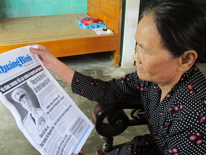 Anh hùng Nguyễn Thị Kim Huế ngắm nhìn ảnh Đại tướng đăng tải trên Báo Quảng Bình ngày 7-10 và nhớ lại những kỷ niệm về Đại tướng Võ Nguyên Giáp.