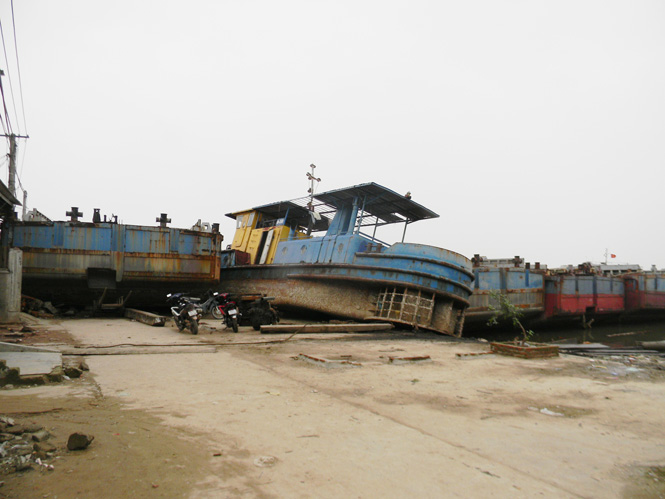 Những chiếc xà lan bị bão số 10 thổi dạt vào khu vực dân cư, chắn lối đi chính của thôn Văn Phú, xã Quảng Văn, huyện Quảng Trạch.
