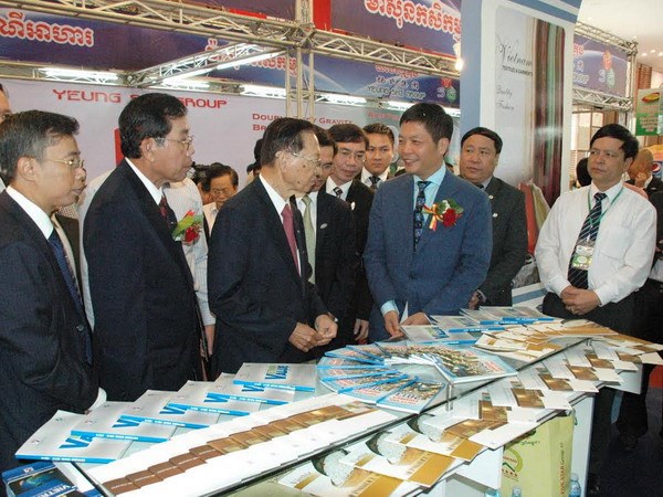 Phó Thủ tướng thường trực Keat Chhon trao đổi với Thứ trưởng Bộ Công thương Trần Tuấn Anh tại gian triển lãm của Việt Nam.(Ảnh: Trần Chí Hùng/Vietnam+)