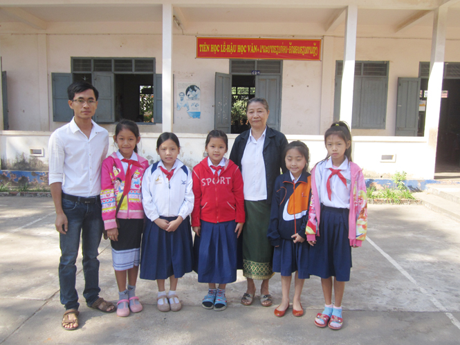 Thầy giáo Việt chụp hình cùng với cô Hiệu trưởng và các em học sinh  Trường Thống Nhất.
