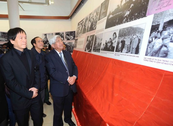 Con trai Đại tướng Võ Nguyên Giáp giới thiệu hình ảnh của Đại tướng với ông Phạm Thế Duyệt, nguyên Chủ tịch Mặt trận Tổ quốc Việt Nam (Nguồn: TTXVN)