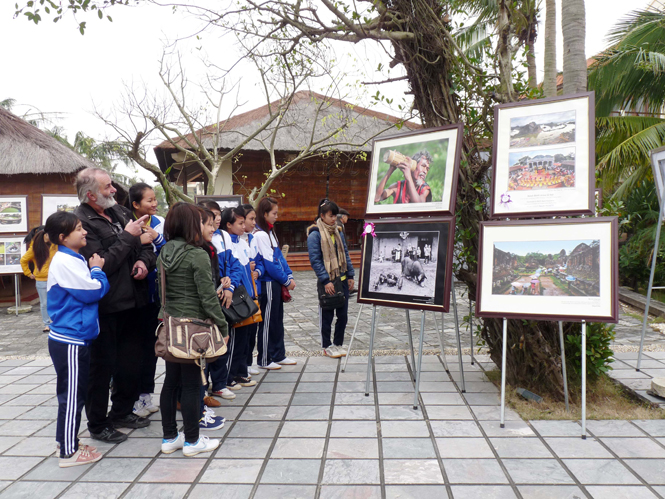 Du khách xem triển lãm ảnh Di sản Việt Nam năm 2013 tại khu nghỉ dưỡng Sun Spa Resort (Bảo Ninh, Đồng Hới). Ảnh: Tiến Hành