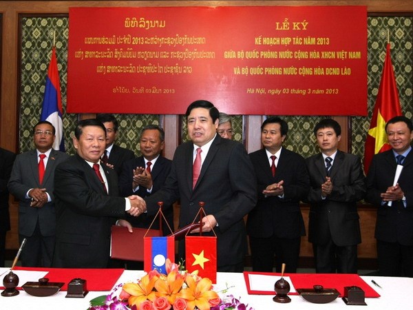 Bộ trưởng Bộ Quốc phòng Phùng Quang Thanh (bên phải) và Phó Thủ tướng kiêm Bộ trưởng Bộ Quốc phòng Lào Douangchay Phichit ký kết kế hoạch hợp tác năm 2013. (Nguồn: Thông tấn quân sự)