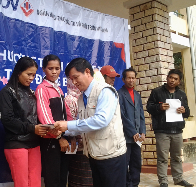 Đại diện lãnh đạo BIDV Quảng Bình trao tặng quà Tết cho hộ nghèo xã Lâm Thủy, huyện Lệ Thủy.