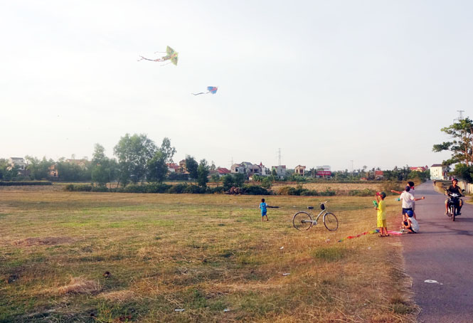 Nhiều em nhỏ vô tư thả diều cạnh các trục đường giao thông nhiều xe cộ qua lại, tiềm ẩn nguy cơ xảy ra tai nạn.